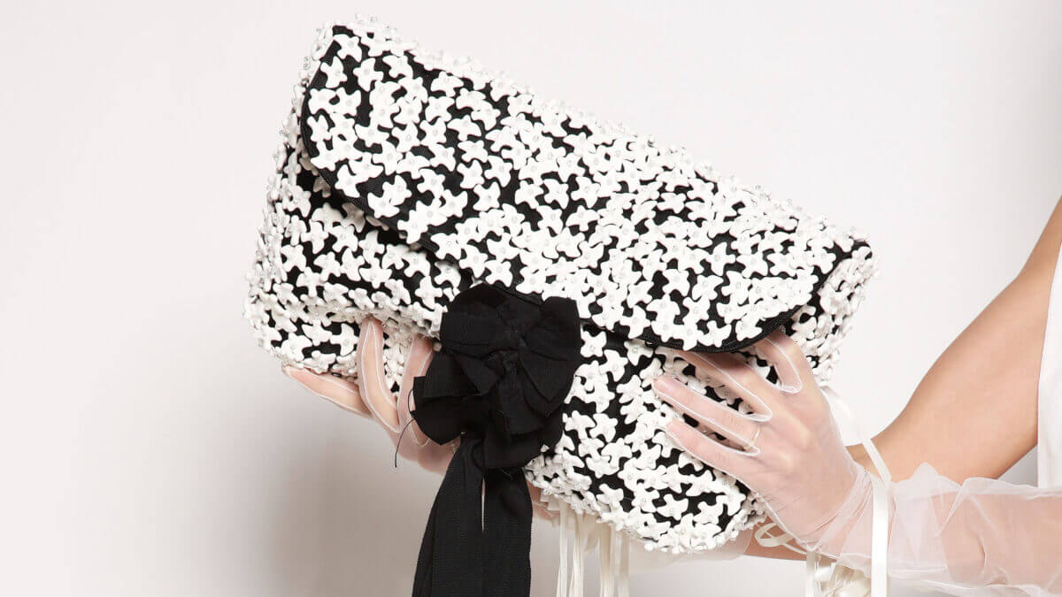 Black and white patterned handbag held by a model