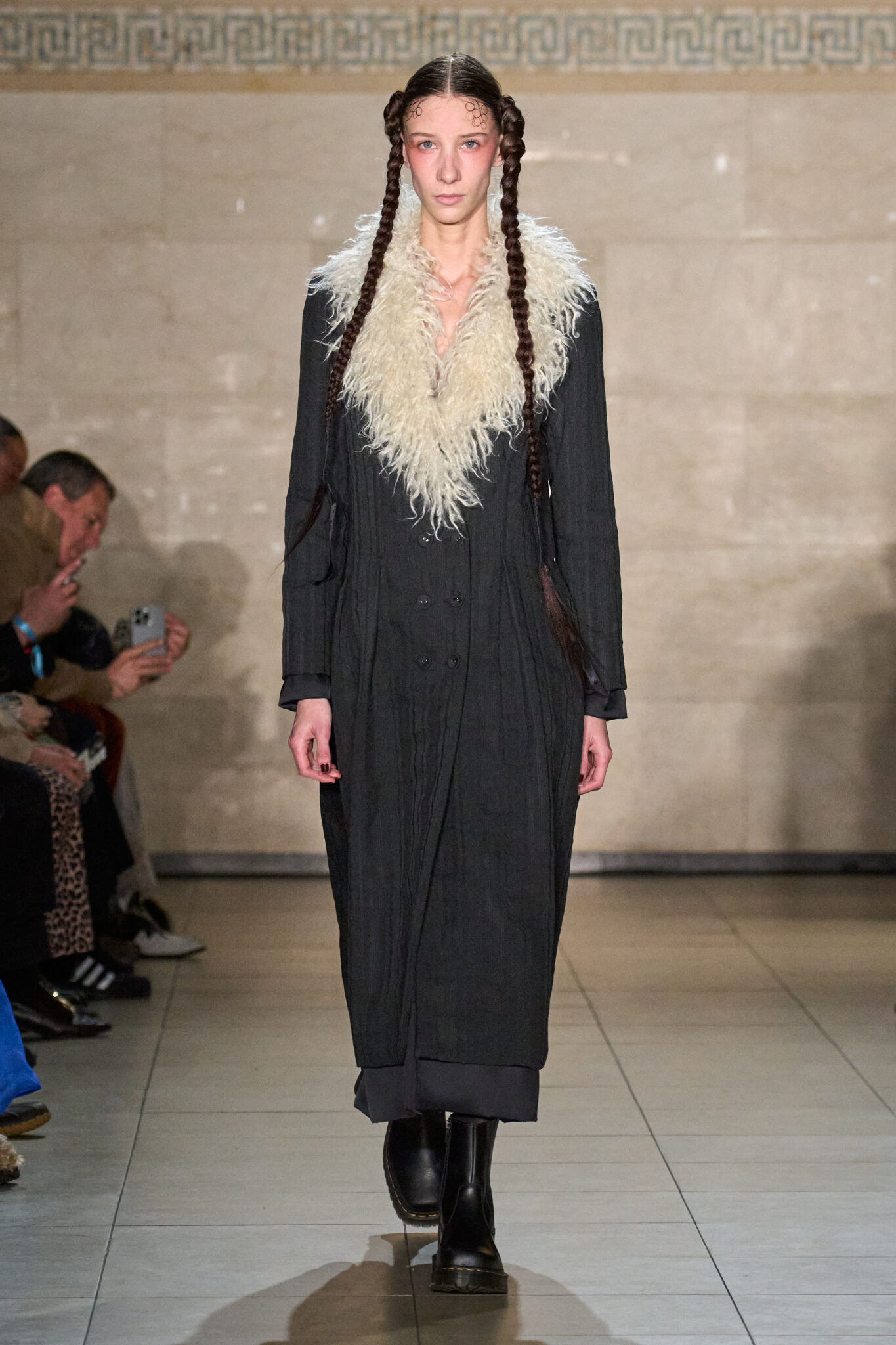 Runway look: long black coat with a cream fur collar, Meruert Tolegen Fall/Winter 2025