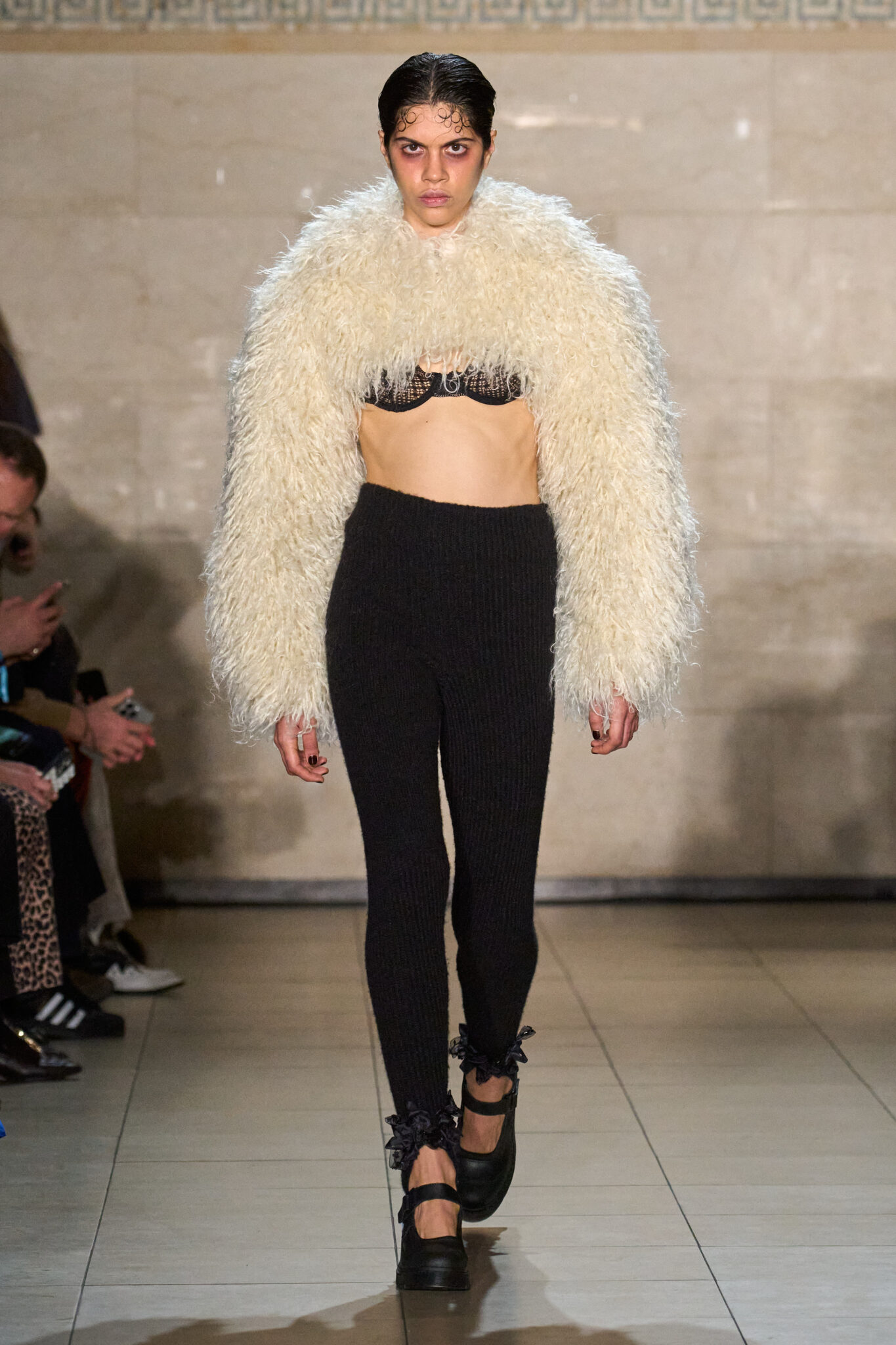 Runway look: cream shearling shrug over a black top and leggings, Meruert Tolegen Fall/Winter 2025